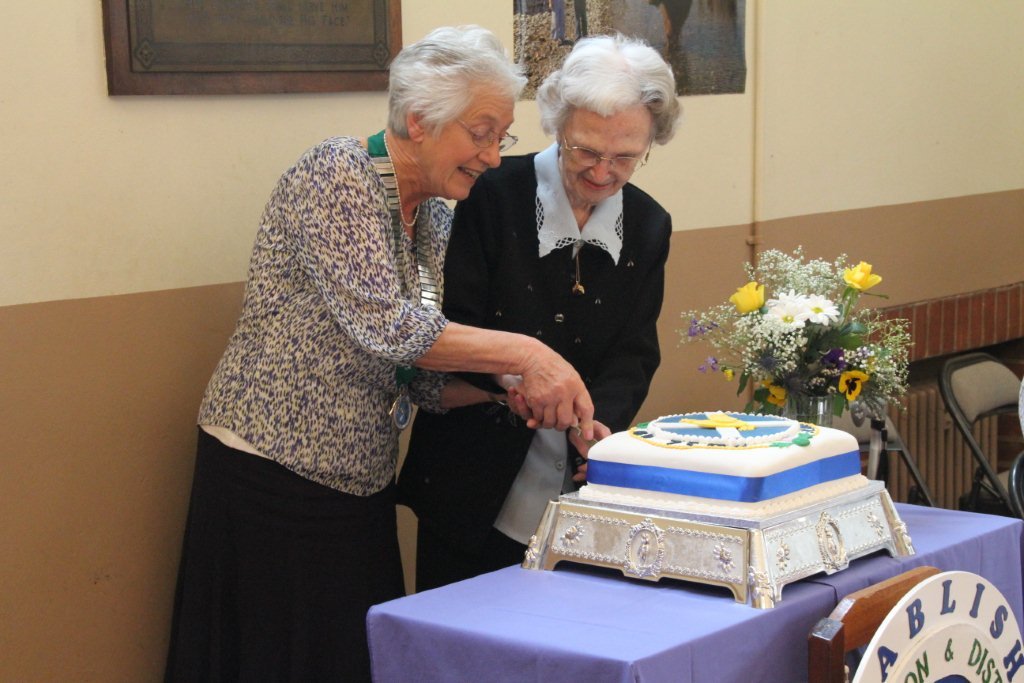 Longest-standing member Esme Bate and Sheila Brown (president) cut the celebratory cake